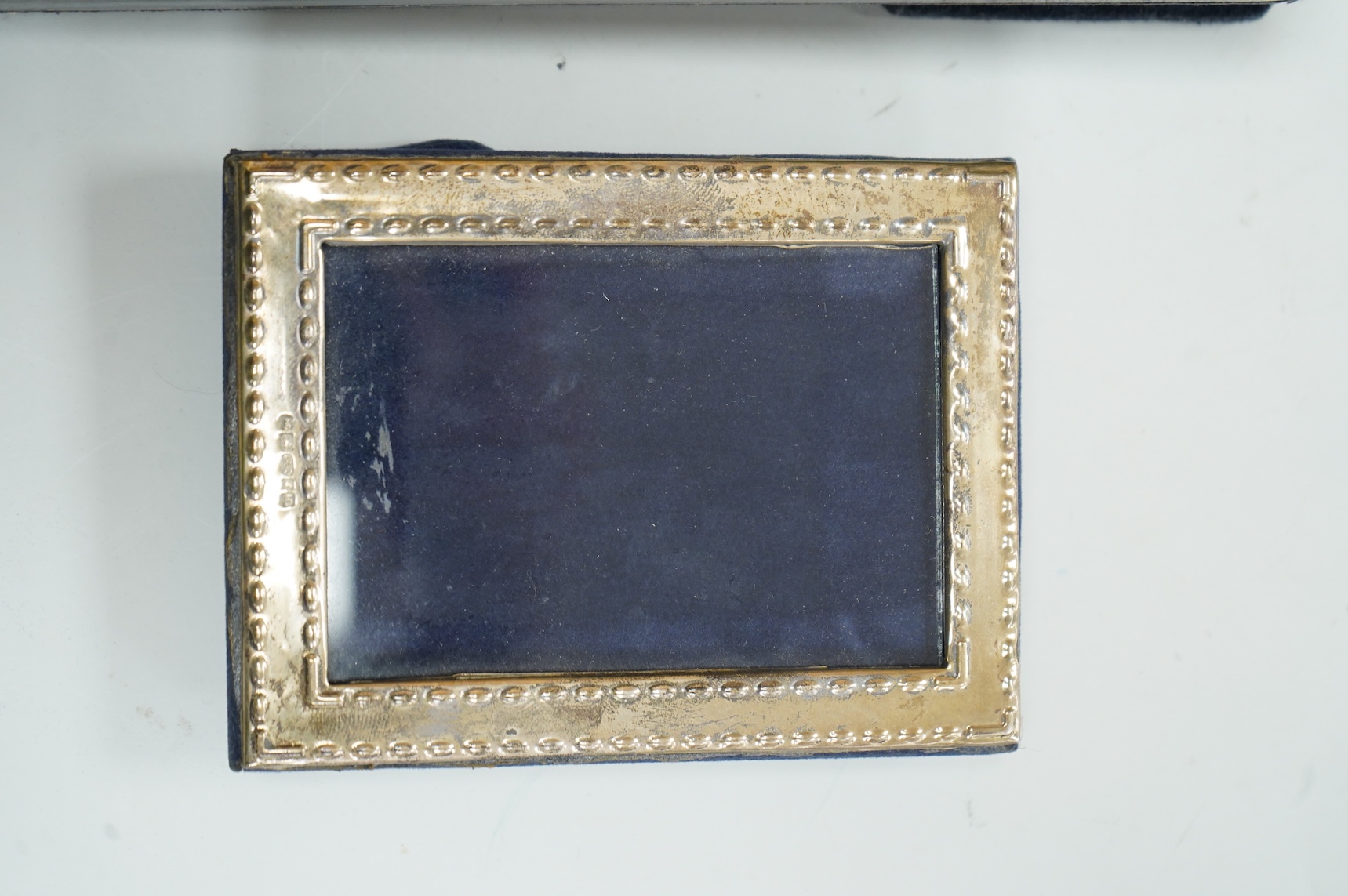 Two modern silver mounted photograph frames, largest 20.4cm by 15.2cm, an Italian 925 mounted photograph frame and a modern silver mounted desk timepiece.